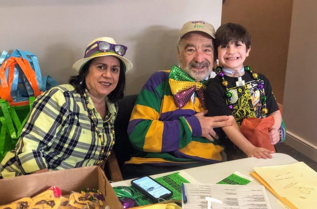 A family dressed for a mardi gras parade with a young man who is autistic